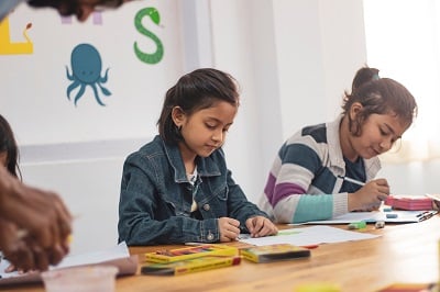 Photo by Pragyan Bezbaruah from Pexels. Girls study in a classroom.