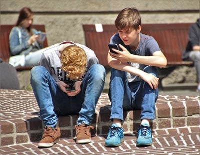 Children look at cell phones.
