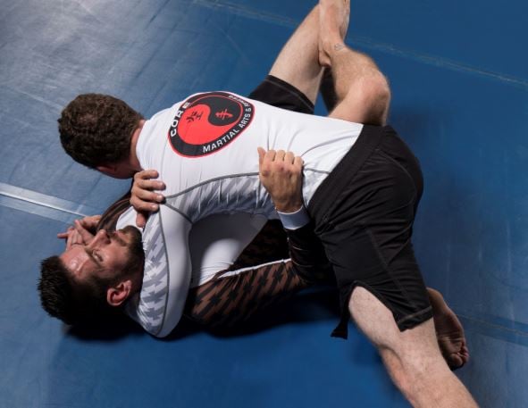 Two grapplers wearing Century's long-sleeve Rank Rash Guard tops and fight shorts. 