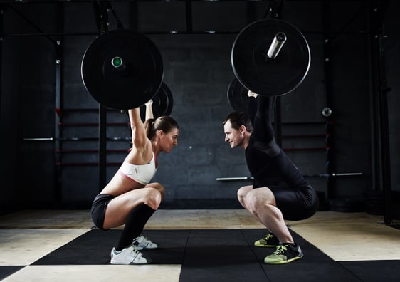 A trainer and her client practice some crazy-hard lift.